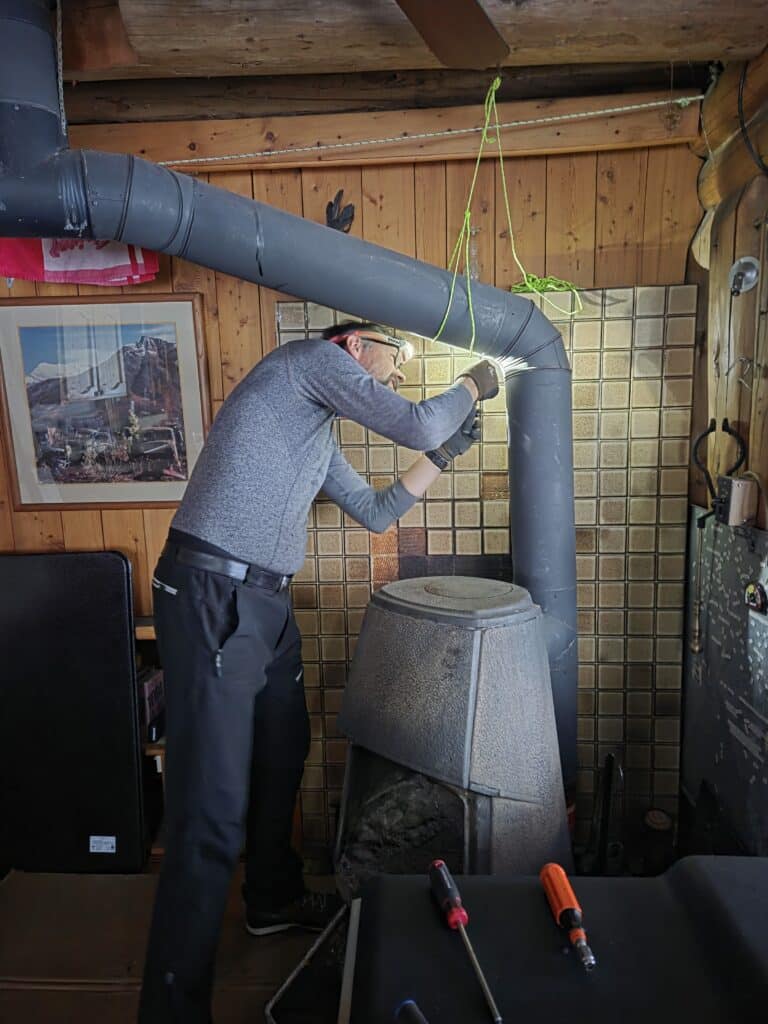 Der alte Ofen wird fachmännisch rückgebaut. Das Ofenrohr hält.